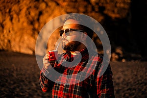 Man sipping a drink under sunlight admiring the scene in Cobquecura, Nuble Region, Chile photo