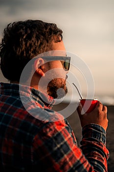 Man sipping a drink under sunlight admiring the scene in Cobquecura, Nuble Region, Chile photo