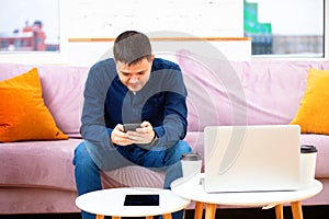 Man sit on the couch and using smartphone