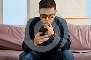 Man sit on the couch and using smartphone