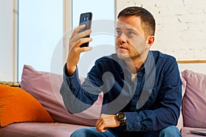 Man sit on the couch and using smartphone