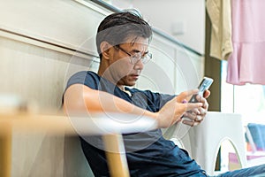 Man sit down and using mobile and social media. Man playing on him Smart phone