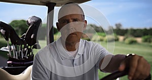 Man sit golf cart on summer course. Luxury player looking camera at country club