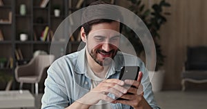 Man sit indoor using mobile phone enjoy time on internet