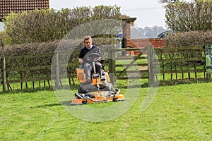 A man on a sit on lawn mower