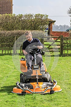 A man on a sit on lawn mower