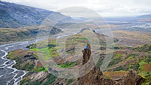 Man siting on a ledge of a mountain, enjoying the beautiful view valley in Thorsmork photo