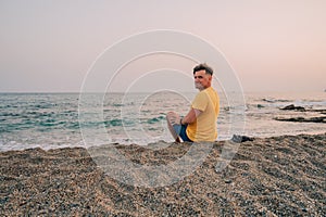 Man sits on the beach and looks at the sea in Alanya city