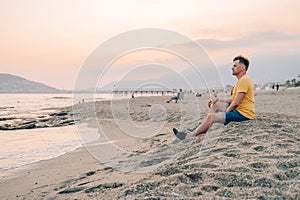 Man sits on the beach and looks at the sea in Alanya city