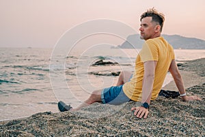 Man sits on the beach and looks at the sea in Alanya city