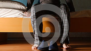 Man sits on a bed in the night at home