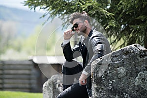 Man Sits Down Strong Outdoors in Nature Posing