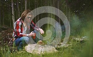 Man sits in front of bonfire