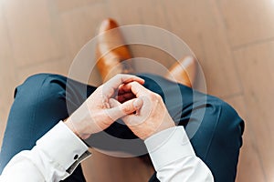 Man sits with hands clasped