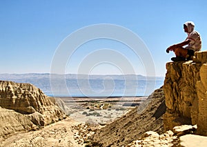 Man sits on a ledge. Canyon Ein Avdat in Negev desert