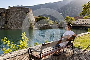 Man sits near Kotor old wall Fortification in Montenegro.