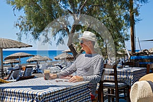 Man sits at a table at a beach cafe