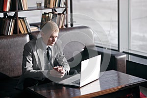 A man sits at a table with a laptop