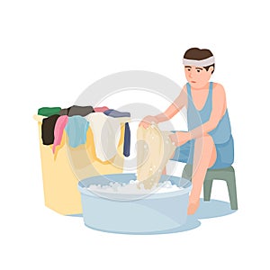 A Man sits washing clothes by hand