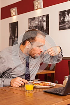 Man sitting alone in restaurant with laptop