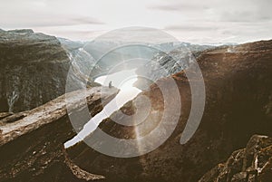 Man sitting alone on Trolltunga cliff edge in Norway