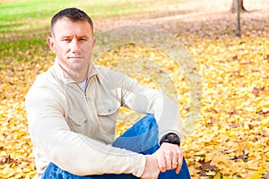 Man Sitting on Autumn Leaves