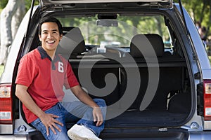 Man sitting in back of van smiling