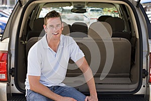 Man sitting in back of van smiling