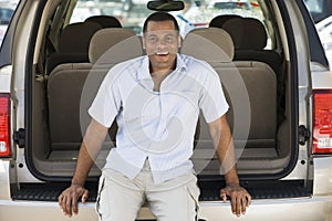 Man sitting in back of van smiling