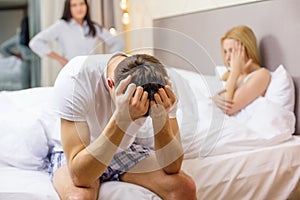 Man sitting on the bed with two women on the back