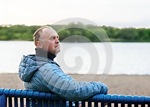 Man sitting on bench near the lake
