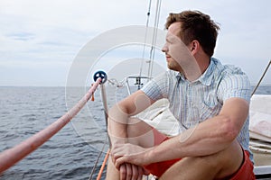 Man sitting on boat sailing on ocean being happy and carefree