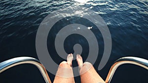 Man sitting at the bow of the boat with feet and legs overboard