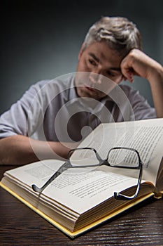 Man sitting at brown table and reading book