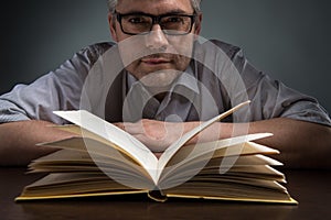 Man sitting at brown table and reading book