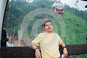 Man sitting in Cable car with Ba Na Hills Mountain in the fog. Landmark and popular. Da Nang, Vietnam and Southeast Asia travel