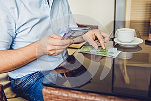 Man sitting in the cafe gives money to another man