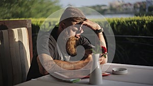 Man sitting at cafeteria or restaurant holding smart phone, looking at its screen. Man using gadget.