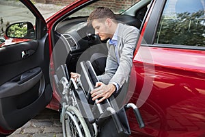 Man Sitting In Car Folding His Wheelchair
