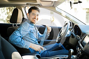 Man sitting in car seat fastening seat belt