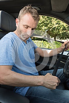 man sitting on car seat fastening seat belt