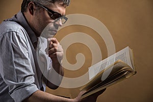 Man sitting in chair and reading book.