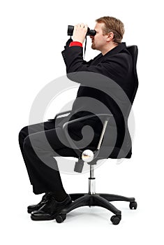 Man sitting in chair and searching with binoculars