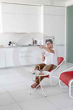 Man sitting in a chair watching tv holding remote control