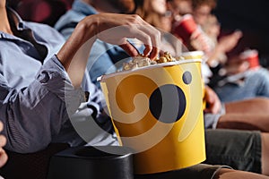 Man sitting in cinema watch film eating popcorn.