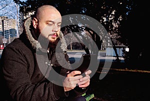 Man sitting in the city park, working with tablet