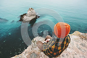 Man sitting on cliff above sea thinking