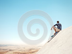 Man sitting on a cliff and desert