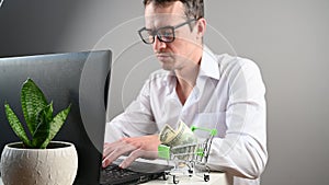 A man sitting at a computer makes online purchases