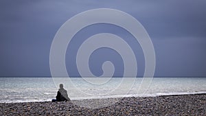 Man sitting in contemplation at beach